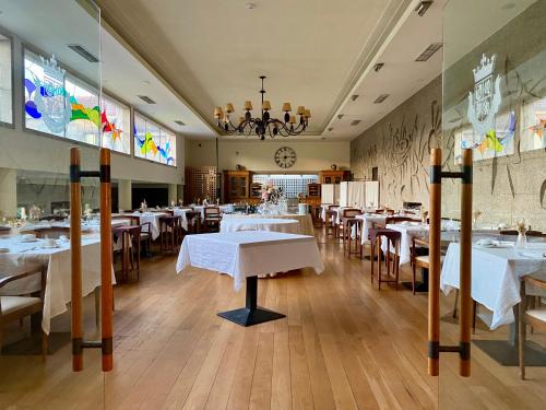 a dining room with white tables and chairs at Hotel de Charme Quinta do Pinheiro in Freamunde