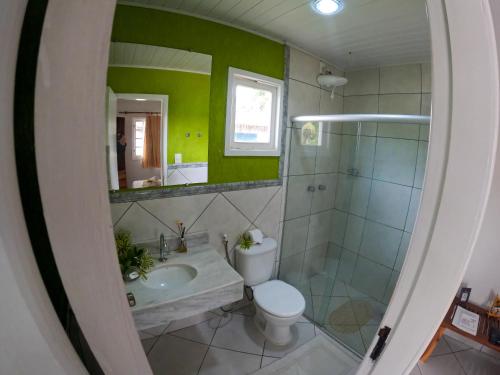 uma casa de banho com um WC, um lavatório e um espelho. em Pousada Corumbau em Corumbau