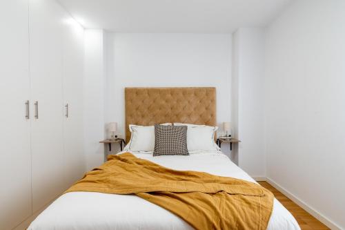 Un dormitorio con una cama con una manta amarilla. en PISO NUEVO EN TRIANA, en Sevilla