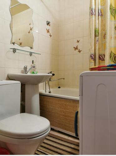 La salle de bains est pourvue de toilettes, d'un lavabo et d'une baignoire. dans l'établissement 1 комн апартаменты в центре рядом с парком, à Kostanay