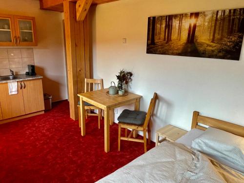 a bedroom with a table and a bed and a kitchen at Chata Boubín in Kubova Huť