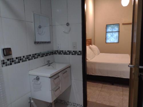 uma pequena casa de banho com um lavatório e uma cama em Pousada Éden em São Jorge