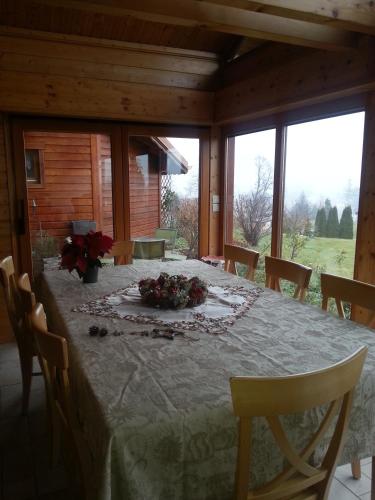 - une table avec des fleurs dans une chambre avec des fenêtres dans l'établissement B&B Chalet l'Epinette, à Gérardmer