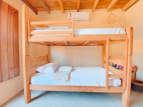 a bedroom with bunk beds in a cabin at Caramuru Hostel Caraíva in Caraíva