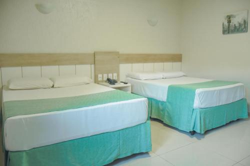 two beds sitting next to each other in a room at Hotel Nacional Inn Foz do Iguaçu in Foz do Iguaçu