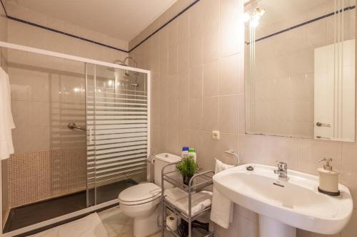 a bathroom with a toilet and a sink and a shower at GAVIDIA CENTER PREMIUM SUITES, FREE PARKING in Seville