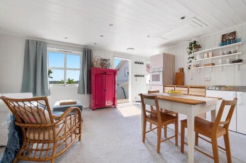 een keuken met een tafel en stoelen en een rode koelkast bij Kragerø hytte havsutsikt in Kragerø