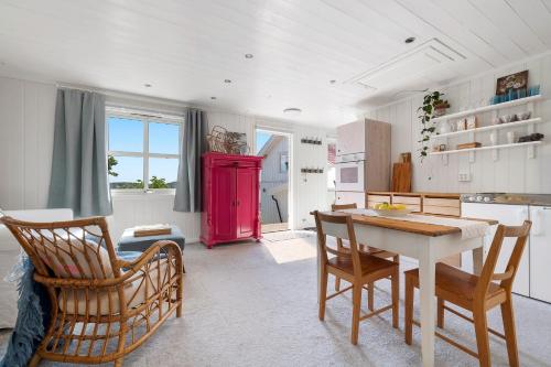 a kitchen with a table and chairs and a red refrigerator at Kragerø hytte havsutsikt in Kragerø