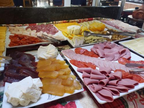 a buffet of different types of cheese and meats at Hotel & Pousada Sonho Meu in Florianópolis