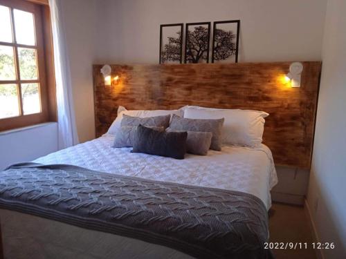 um quarto com uma cama grande e uma cabeceira em madeira em A Casa Azul - Igatu em Igatu