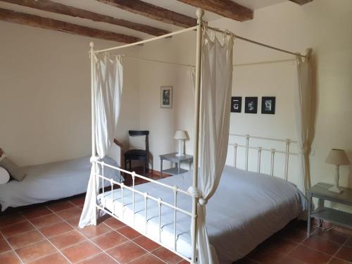 sypialnia z łóżkiem z baldachimem i stołem w obiekcie Chambre d'hôte La Pierre w mieście Conne-de-Labarde