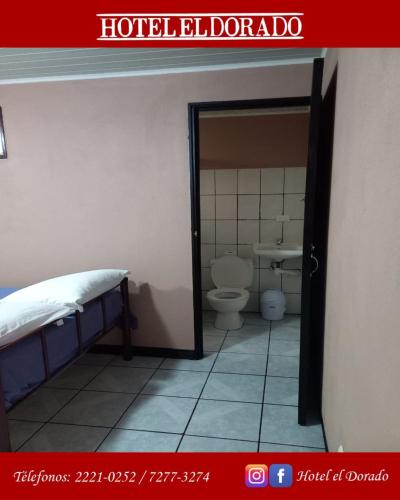 a bathroom with a bed and a toilet in a room at Hotel El Dorado in San José