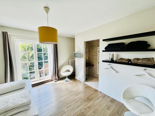 a living room with white furniture and a large window at Le Coin Vert in Bruges