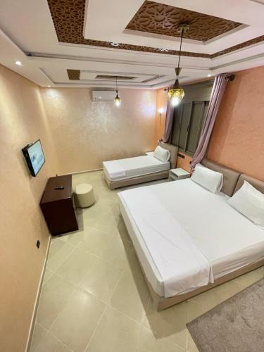 1 dormitorio con 2 camas y TV. en IGHIZ INN resort en Er-Rachidía