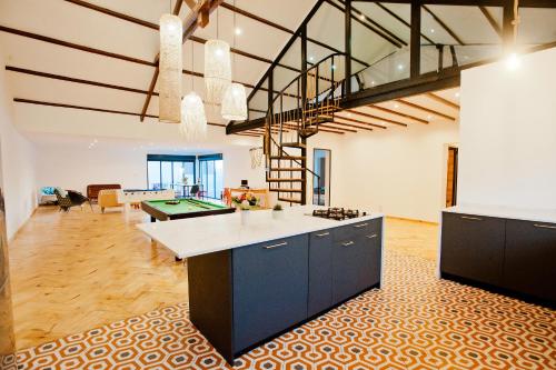 an open kitchen and living room with a pool table at Joyau secret # Jardin # Piscine # Bien-être # prox centre ville in Antananarivo