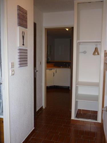 un couloir avec une porte menant à une cuisine accessible par un escalier. dans l'établissement Residence des Pecheurs, au Cap d'Agde