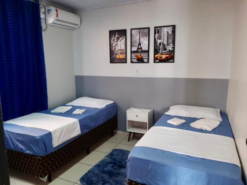dwa łóżka w pokoju niebiesko-białym w obiekcie Casa no Centro (Orla de Marabá) w mieście Marabá