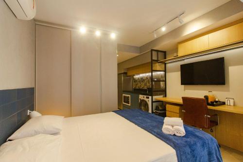 a bedroom with a bed and a desk and a television at Studios Próximo a Av Paulista com Piscina no Rooftop e Sauna in Sao Paulo