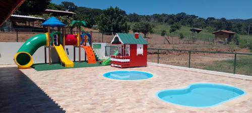 un parco giochi con uno scivolo e una struttura ludica di Pousada Quinzitão - O seu local de descanso! a Extrema