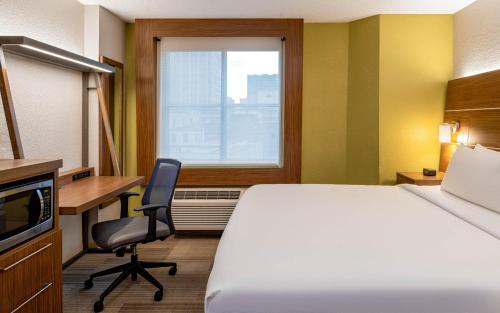 a hotel room with a bed and a desk and a window at Holiday Inn Express New Orleans Downtown by IHG in New Orleans