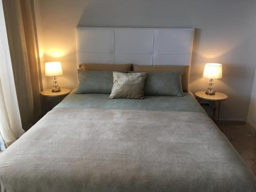 a bedroom with a large bed with two lamps at Las Palmas 3 in Marbella