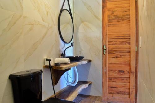 a bathroom with a sink and a mirror on a wall at Kanaloa Village 02 in Icaraí
