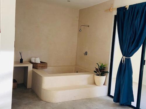 baño con bañera y cortina azul en Santuario Jungle, en Akumal