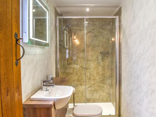 een badkamer met een douche, een wastafel en een toilet bij Swallow Barn in Hargrave