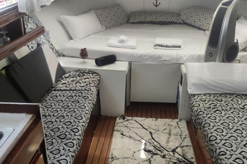 Habitación pequeña con cama y sofá en PRECIOSO BARCO EN EL PUERTO DE BADALONA, en Badalona