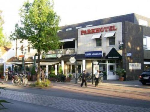 a building on a street with people walking in front of it at Park Hotel in Bad Zwischenahn