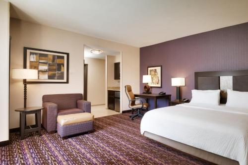 ビリングスにあるHoliday Inn Express Hotel & Suites Billings, an IHG Hotelのベッド、デスク、椅子が備わるホテルルームです。