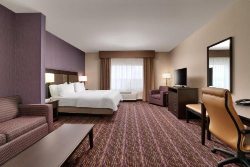 a large hotel room with a bed and a couch at Holiday Inn Express Hotel & Suites Billings by IHG in Billings