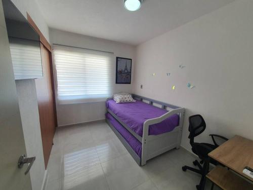 a bedroom with a purple bed and a desk at Departamento de lujo en Manzanillo, planta baja frente a la alberca in Manzanillo