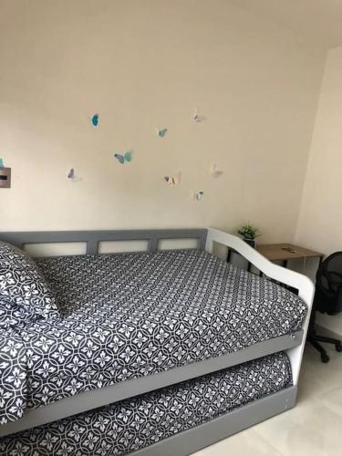 a bedroom with a bed with butterflies on the wall at Departamento de lujo en Manzanillo, planta baja frente a la alberca in Manzanillo
