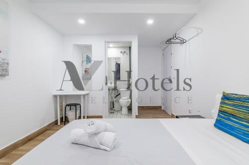 a white bedroom with a white bed and a bathroom at A&Z El Cano - Auto check-in property in Málaga