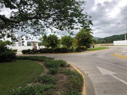 an empty street in a residential neighborhood with trees at Departamento de lujo en Manzanillo, planta baja frente a la alberca in Manzanillo