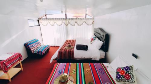 ein Schlafzimmer mit einem Bett und einem Stuhl darin in der Unterkunft Uros Utasa Lodge in Puno