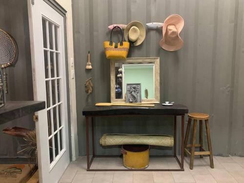 a vanity with a mirror and a hat and a stool at Wabi Sabi , beach home in Tamanique