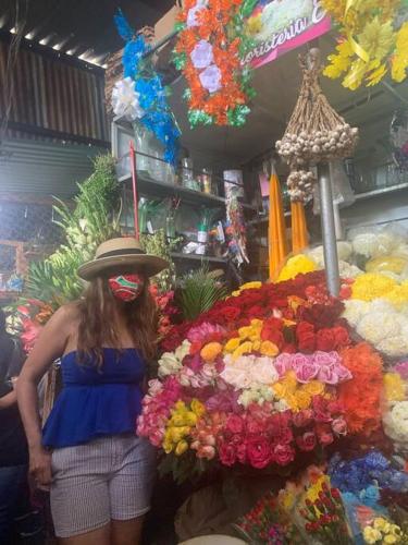 a woman wearing a hat standing next to a pile of flowers at Wabi Sabi , casa de playa in Tamanique