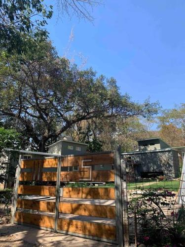 a wooden fence in front of a tree at Wabi Sabi , casa de playa in Tamanique