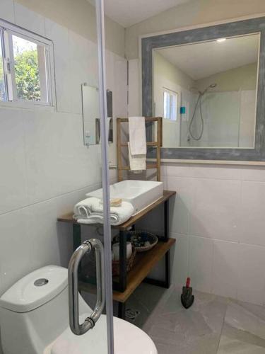 a bathroom with a toilet and a sink and a mirror at Wabi Sabi , casa de playa in Tamanique