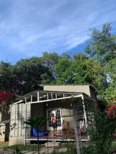 a woman standing in the window of a small house at Wabi Sabi , casa de playa in Tamanique