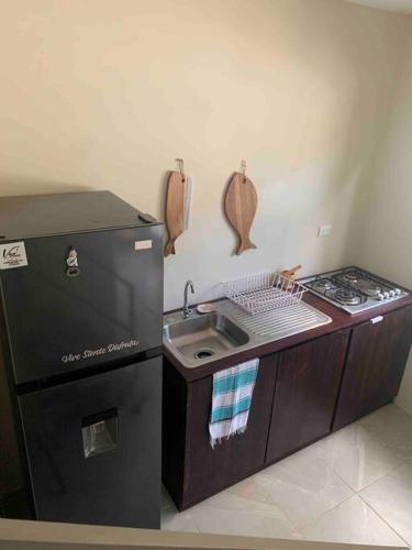 a small kitchen with a sink and a stove at Wabi Sabi , casa de playa in Tamanique