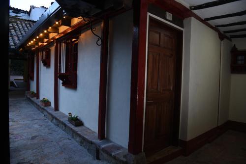a row of houses with a wooden door and lights at Hotel Cacique Real in Zipaquirá