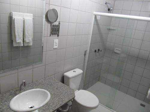 a bathroom with a toilet and a sink and a shower at Hotel Porto do Sol in Caetité