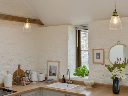 a kitchen with two pendant lights and a sink at The Chaff House in Wookey