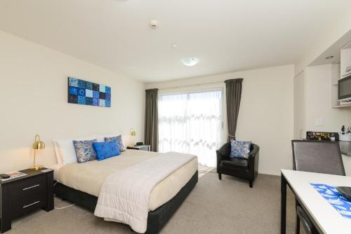 a bedroom with a large bed and a window at Ellena Court Motel in Blenheim