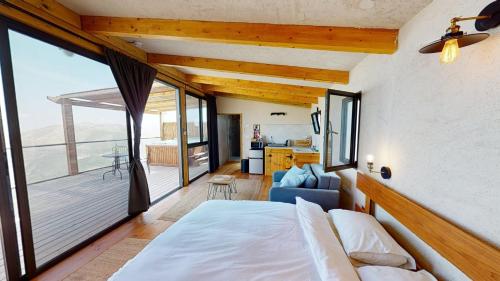 1 dormitorio con 1 cama y balcón en Genesis Land Desert hospitality, en Kfar Adumim