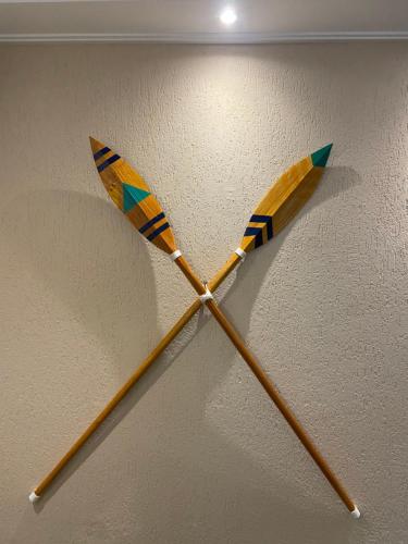a pair of wooden arrows on a wall at Pousada As Ondas in Guarujá