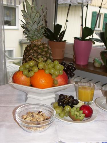 a table with a plate of fruit on a table at Pension Wölfel in Bad Steben